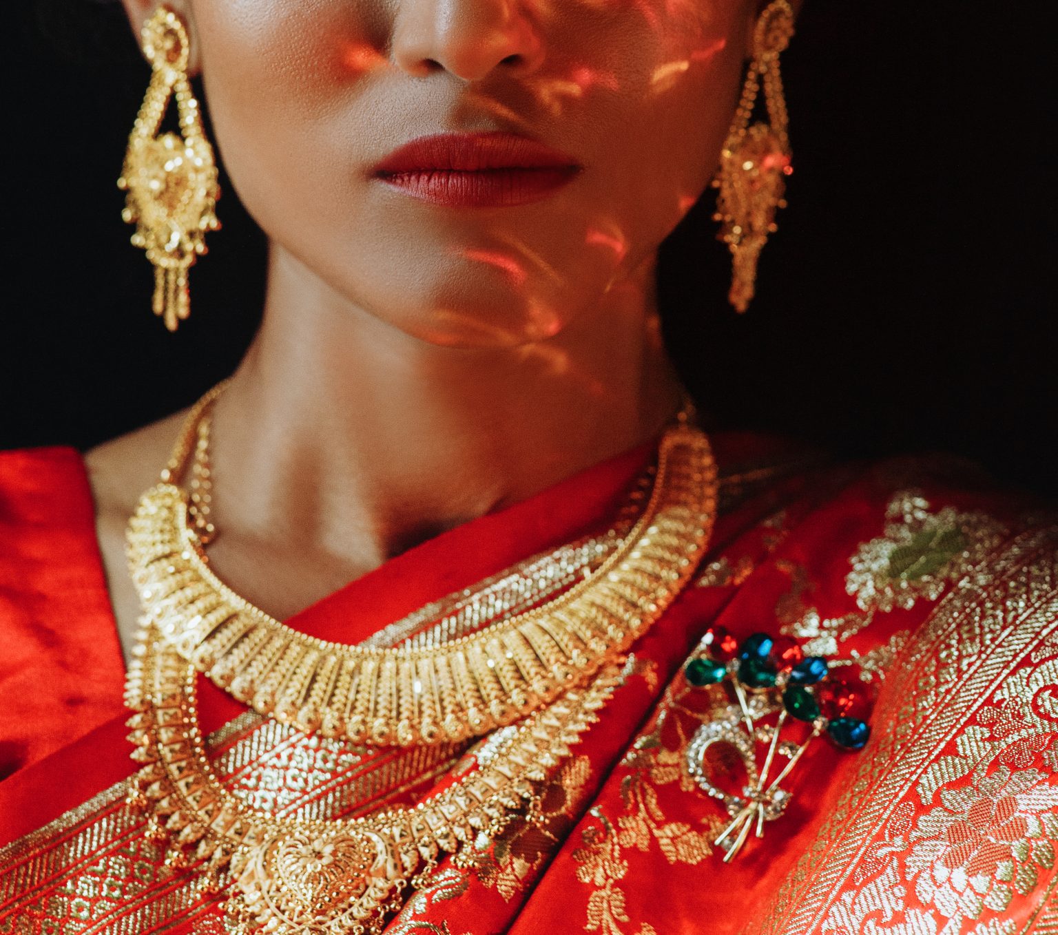 Portrait of Hindu bride in traditional red sari with golden accessories