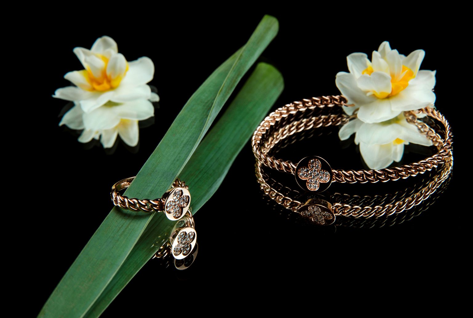 side view of jewelry set of golden bracelet and ring with diamonds